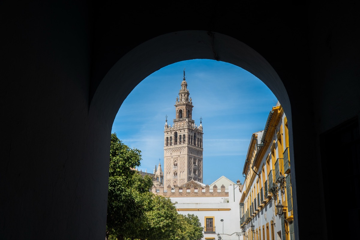 A Moorish arch framing the Gothic spires of Seville Cathedral